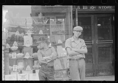 Two boys standing in front of candy store window, street scene,…, Ohio, 1938