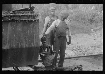 Workers repairing Route 40, central Ohio. Vat for heating tar used in…, 1938