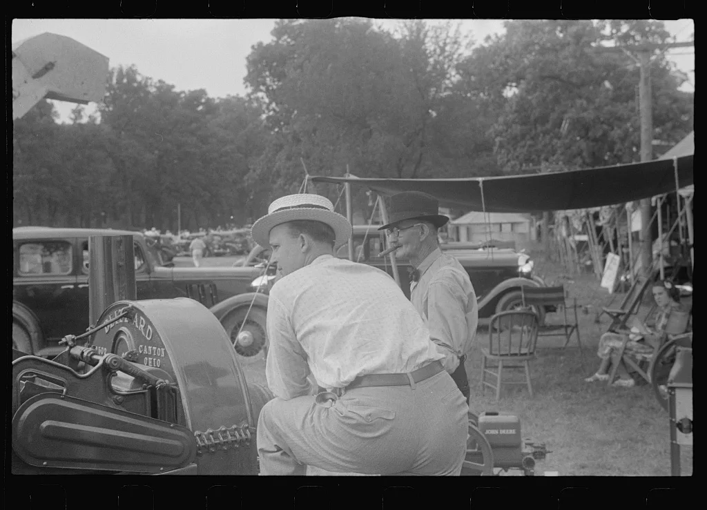 Attendants at farm machinery display at county fair, central Ohio, 1938