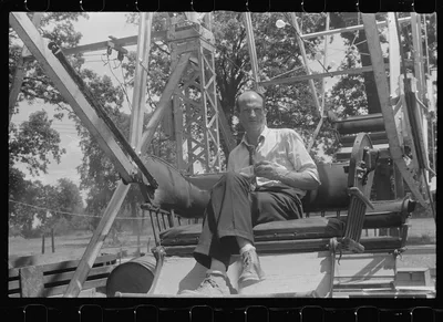 Operator of ferris wheel resting at county fair in central Ohio, 1938