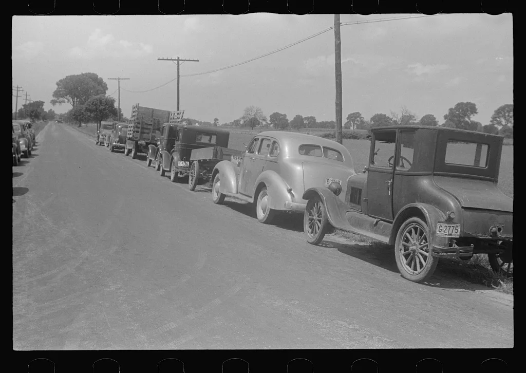 Farmers' cars parked along highway near a public auction, central Ohio, 1938